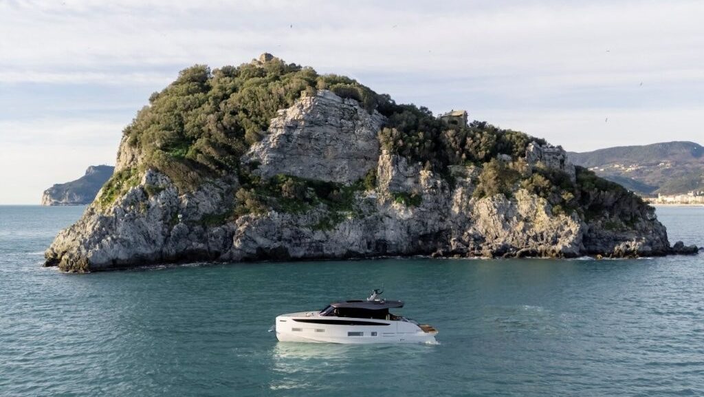 Azimut white motor yacht at sea with cliff backdrop