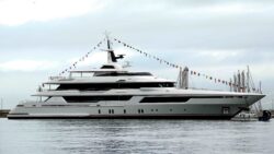 Large white superyacht with bunting